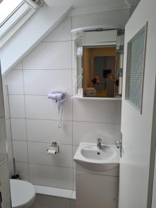 a white bathroom with a sink and a toilet at Hotel Löhr in Baden-Baden
