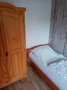 1 dormitorio con armario de madera junto a la cama en Nordsee-Ferienanlage-Wohnung-Norderney, en Dornumersiel