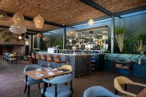 un restaurante con mesas y sillas y un bar en Laborie Estate en Paarl