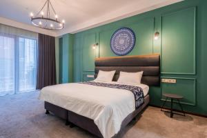 Matiane Boutique Hotel في تبليسي: غرفة نوم بسرير كبير وبجدران خضراء