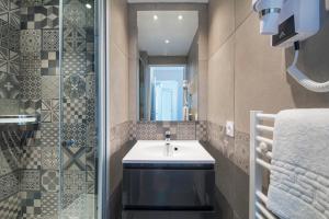 uma casa de banho com um lavatório e um espelho em Hôtel-Club du Domaine d'Aiguebelle, USSIM Vacances em Le Lavandou