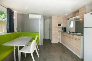 a kitchen with a table and chairs and a refrigerator at Camping la Croix du Sud in Saint-Tropez