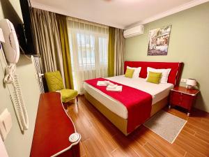 um quarto de hotel com uma cama com um cobertor vermelho em Art Green Boutique Hotel em Varna City