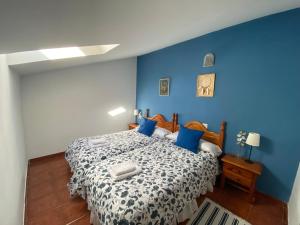 - une chambre bleue avec un lit aux murs bleus dans l'établissement Alojamientos El Horno, à Montejo de la Sierra