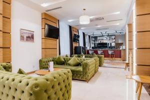a living room with green couches and a table at Ramada by Wyndham Astana in Astana