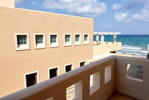 a view of the ocean from the balcony of a building at Niros Beachfront Aparthotel in Kokkíni Khánion