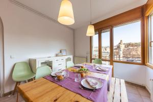 comedor con mesa de madera y sillas verdes en Bravissimo El Lleó, bright 4-bedroom apartment, en Girona