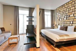 een slaapkamer met een bed en een bakstenen muur bij Boutique Hotel Saint-Géry in Brussel