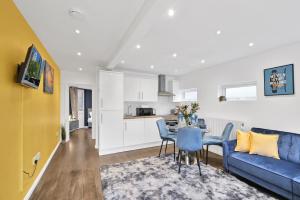 een woonkamer met een blauwe bank en een tafel bij Kings House Apartment Hayes, West London Apt A in Northolt