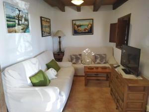 a living room with a white couch and a tv at Caseta de Susana in Deltebre