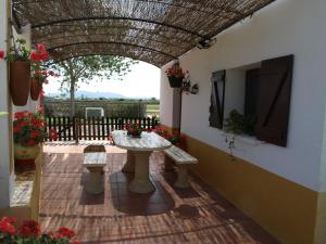 a patio with a table and benches in a building at Caseta de Susana in Deltebre