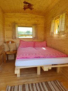 een groot bed in een houten kamer in een hut bij Gemütlicher Schäferwagen im Grünen-Schäferwagen 44 in Frielendorf