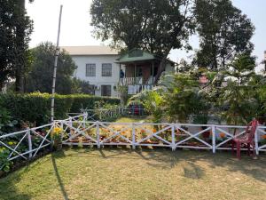 une clôture blanche devant une maison dans l'établissement Samriddhi Banquet Garden & Resorts, à Baharampur
