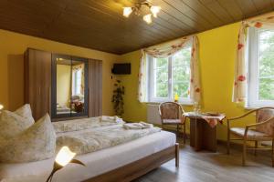 - une chambre avec un lit, une table et deux fenêtres dans l'établissement Kräuterbaude, à Saupsdorf