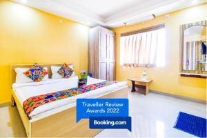 a bedroom with yellow walls and a bed with colorful pillows at FabHotel Amaltas in Rānchī