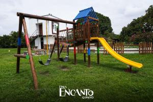 einen Spielplatz mit Rutsche im Gras in der Unterkunft FINCA HOTEL Encanto Quindio in La Tebaida