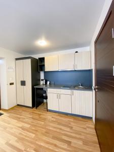 a kitchen with white cabinets and a blue wall at "AVA" apgyvendinimo įstaiga in Vilnius