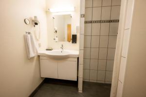 
a bathroom with a sink and a mirror at Nymindegab Kro in Nørre Nebel
