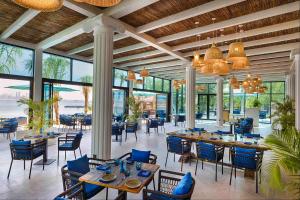 une salle à manger avec tables, chaises et fenêtres dans l'établissement Anantara World Islands Dubai Resort, à Dubaï