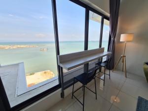 een kamer met een bureau en uitzicht op de oceaan bij Sunrise Gurney Executive Premium Suite in George Town
