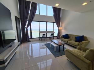 Una sala de estar con un sofá, un televisor y una mesa. en Sunrise Gurney Executive Premium Suite, en George Town