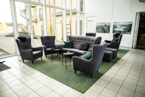 
a living room filled with couches and chairs at Nymindegab Kro in Nørre Nebel
