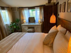 a bedroom with a bed with a television on a desk at Dovecote Cotswold Cottages in Chipping Norton