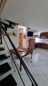 - une salle à manger et une cuisine avec une table et des chaises dans l'établissement Leonardo Home, à Caserte