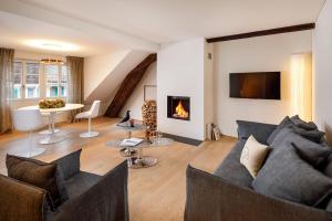 a living room with a couch and a fireplace at La Colombe Boutique Hotel in Zug