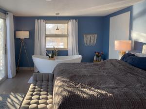 a blue bedroom with a bed and a bath tub at Lucky Stone Retreat - private beach & Acadia view in Sullivan
