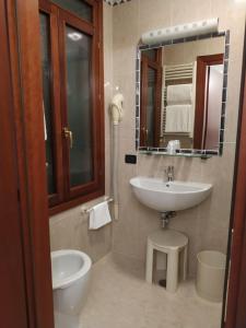 a bathroom with a sink and a mirror and a toilet at Atlantide Hotel in Venice +67 photos