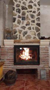 a stone fireplace with a fire in it at El encinar de las Hoces - Vivienda de uso turístico in Castrillo de Sepúlveda