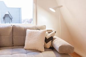- un canapé dans le salon doté d'une fenêtre dans l'établissement Bheaven I Skandi Premium Apartment, à Bremerhaven