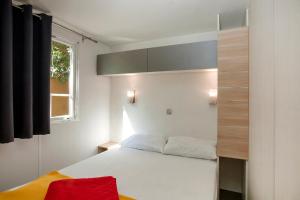 a small bedroom with a bed and a window at Camping la Croix du Sud in Saint-Tropez