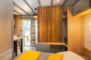 a bedroom with a bed and a wooden wall at Camping la Croix du Sud in Saint-Tropez