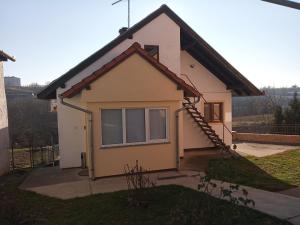 a small house with a staircase in a yard at Apartman Verona in Ilok