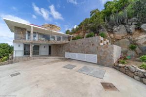 a house with a large patio with an umbrella at VILLA ANGEL ROCK in Saint Barthelemy