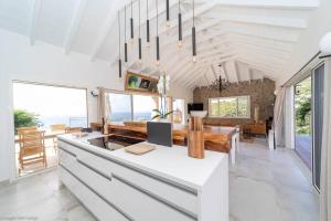 a kitchen with a white counter and a dining room at VILLA ANGEL ROCK in Saint Barthelemy