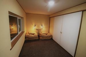 ein kleines Zimmer mit zwei Betten und einer Lampe in der Unterkunft SHIP in Nemuro