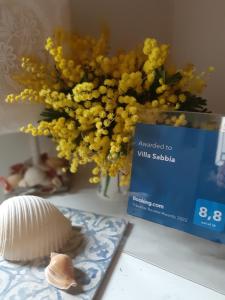 a vase of yellow flowers sitting next to a book at Villa Vathi in Granelli