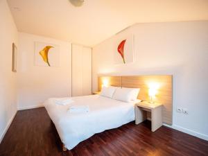 a bedroom with a bed and a lamp at Residhotel St Etienne Centre in Saint-Étienne