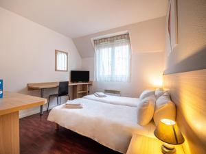 a room with a bed and a desk with a computer at Residhotel St Etienne Centre in Saint-Étienne