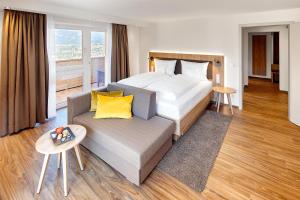 Habitación de hotel con cama y sofá en Hotel Kühberg, en Oberstdorf