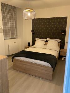 een slaapkamer met een groot bed met een zwart hoofdeinde bij Résidence avec un T3 un T2 et un STUDIO en Centre Ville d Argeles-Gazost in Argelès-Gazost