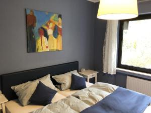 1 dormitorio con 1 cama y una pintura en la pared en Ferienhaus Schöner Maarblick en Schalkenmehren