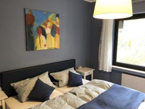 1 dormitorio con 1 cama y una pintura en la pared en Ferienhaus Schöner Maarblick, en Schalkenmehren