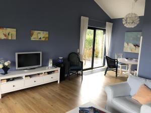 una sala de estar con TV en un armario blanco en Ferienhaus Schöner Maarblick en Schalkenmehren