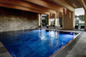 an infinity pool with blue water in a building at Fjordgaarden - Kurbad - Hotel - Konference in Ringkøbing