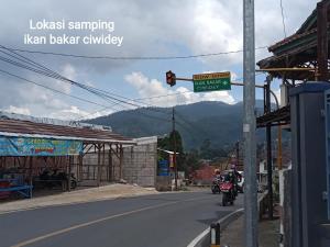 a man riding a motorcycle down a street at Penginapan atau Kontrakan Rumah Ciwidey 1 Ruangan 2 Kasur Dewasa Kamar Mandi Dapur Dalam Sewa Harian Mingguan Bulanan Tahunan Boleh in Ciwidey