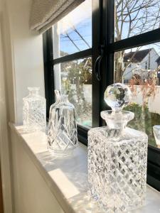 a group of glass vases sitting on a window sill at The Little Limes - Ensuite Double Room Own Entrance in Art Deco House in Kent